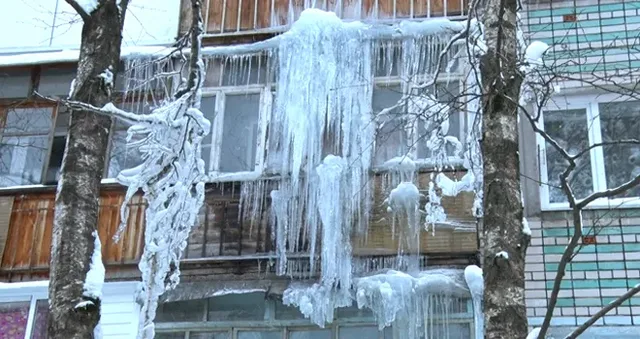 Закованные во льдах: огромные глыбы и сосульки свисают с балконов дома на улице Щорса в Дзержинске